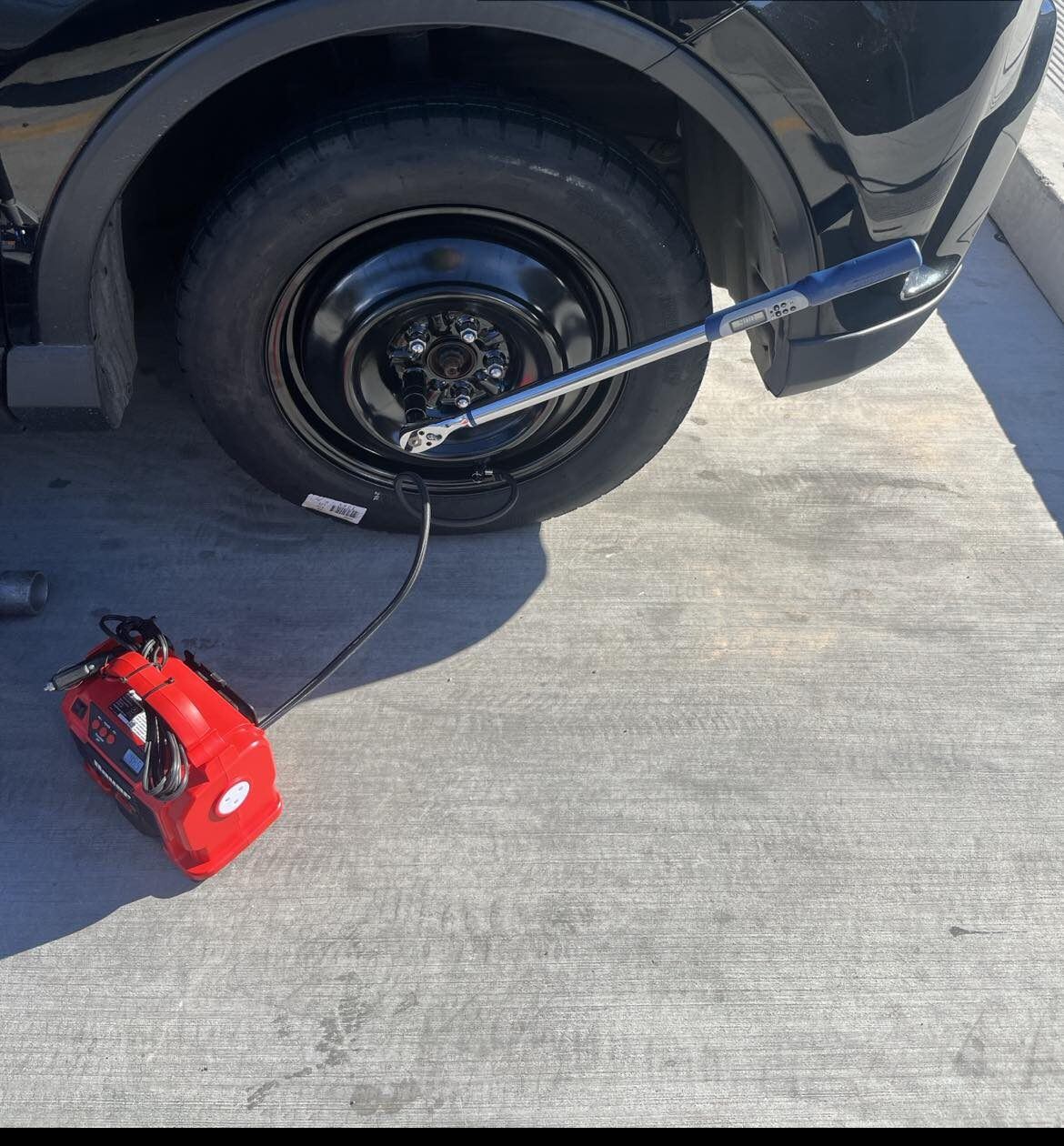 Technician installing a spare tire roadside